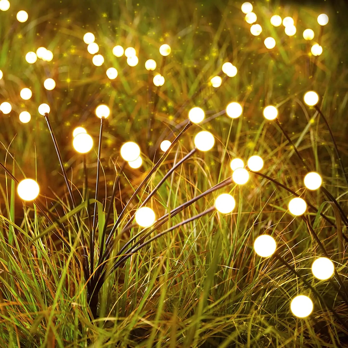 NdotoHuis™ Solar Firefly Lights in an outdoor garden setting, showcasing their warm, firefly-like glow and waterproof design. The lights are staked into the ground and create a magical, inviting atmosphere with multiple lighting modes.