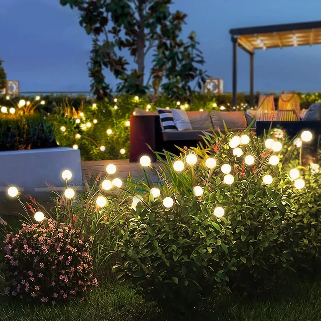 NdotoHuis™ Solar Firefly Lights in an outdoor garden setting, showcasing their warm, firefly-like glow and waterproof design. The lights are staked into the ground and create a magical, inviting atmosphere with multiple lighting modes.