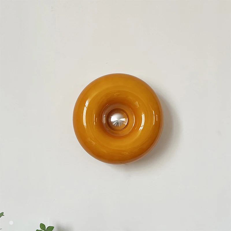 Ornate vintage French table lamp with a warm yellow glass shade and a decorative metal base on a wall.