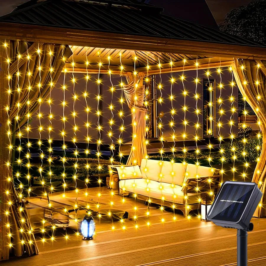 SolarCurtain™ Waterproof LED Fairy Lights illuminating a beautiful outdoor garden space with a warm, enchanting glow, showcasing their durable and versatile design perfect for both indoor and outdoor festive decorations.